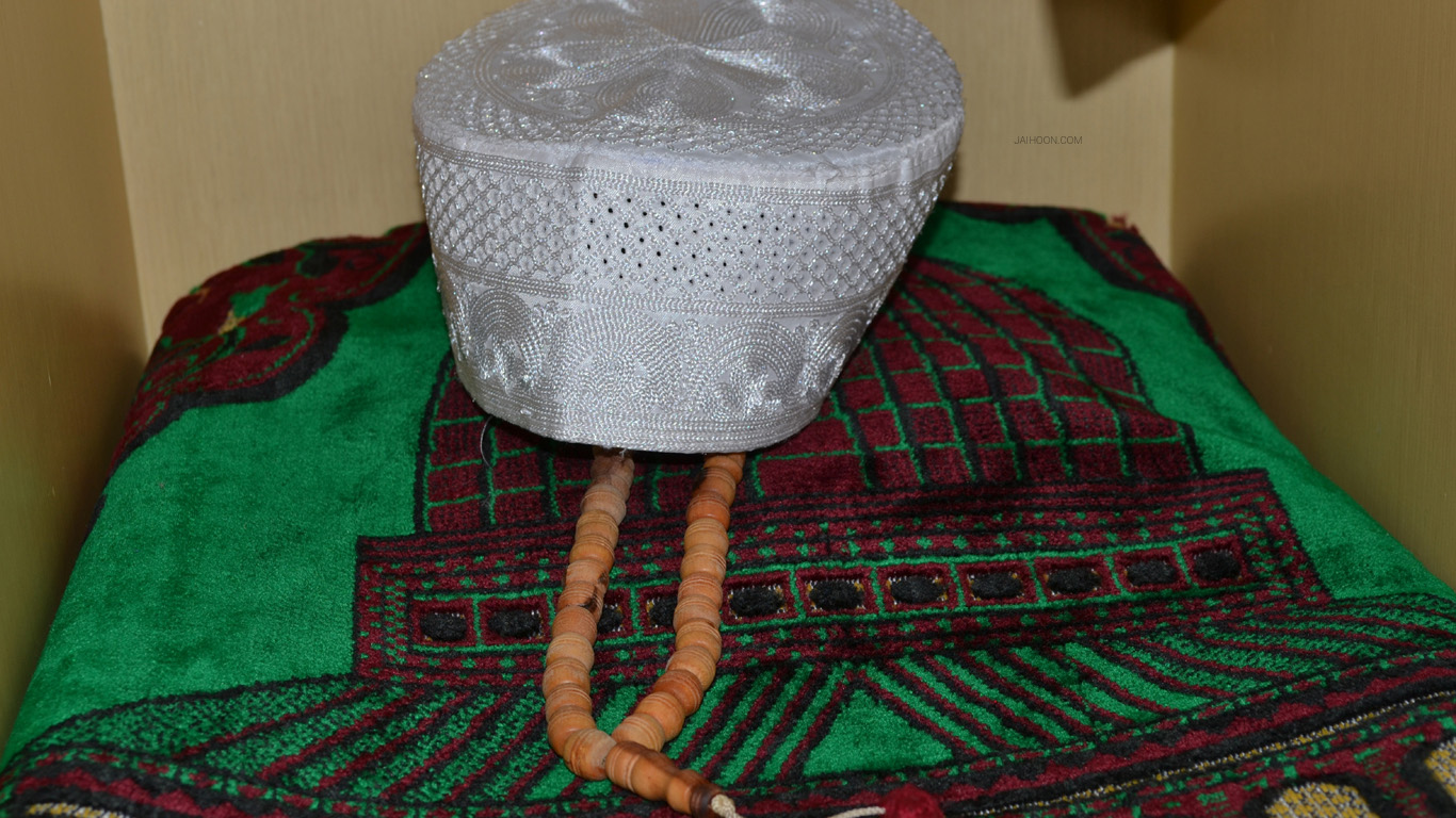 Prayer rug, cap and rosary inside hotel in Urumqi